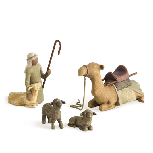 Set of nativity scene figurines including a shepherd, sheep, and camel on a white background