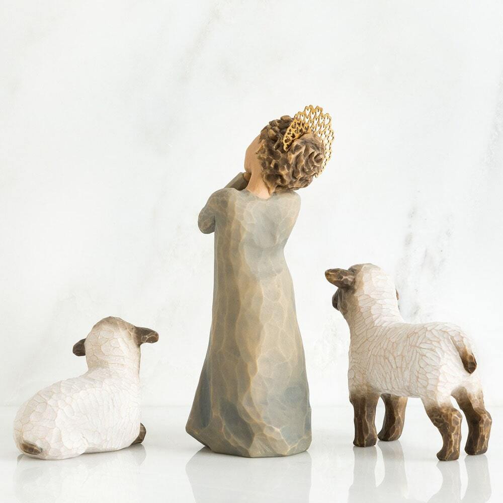 Decorative figurine of a woman with a crown and two sheep on a white background