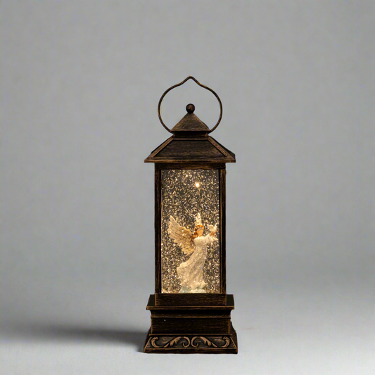 Decorative lantern with an angel figure inside on a gray background christmas snow globe