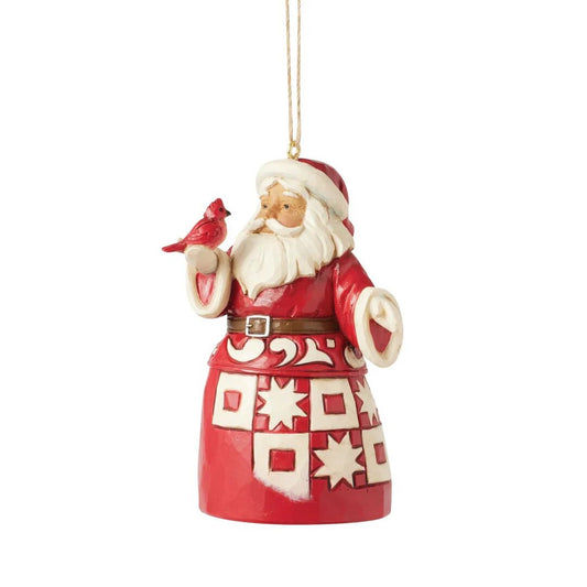 Decorative Christmas ornament of a Santa Claus figure with a red and white patterned coat, holding a cardinal bird, on a white background.