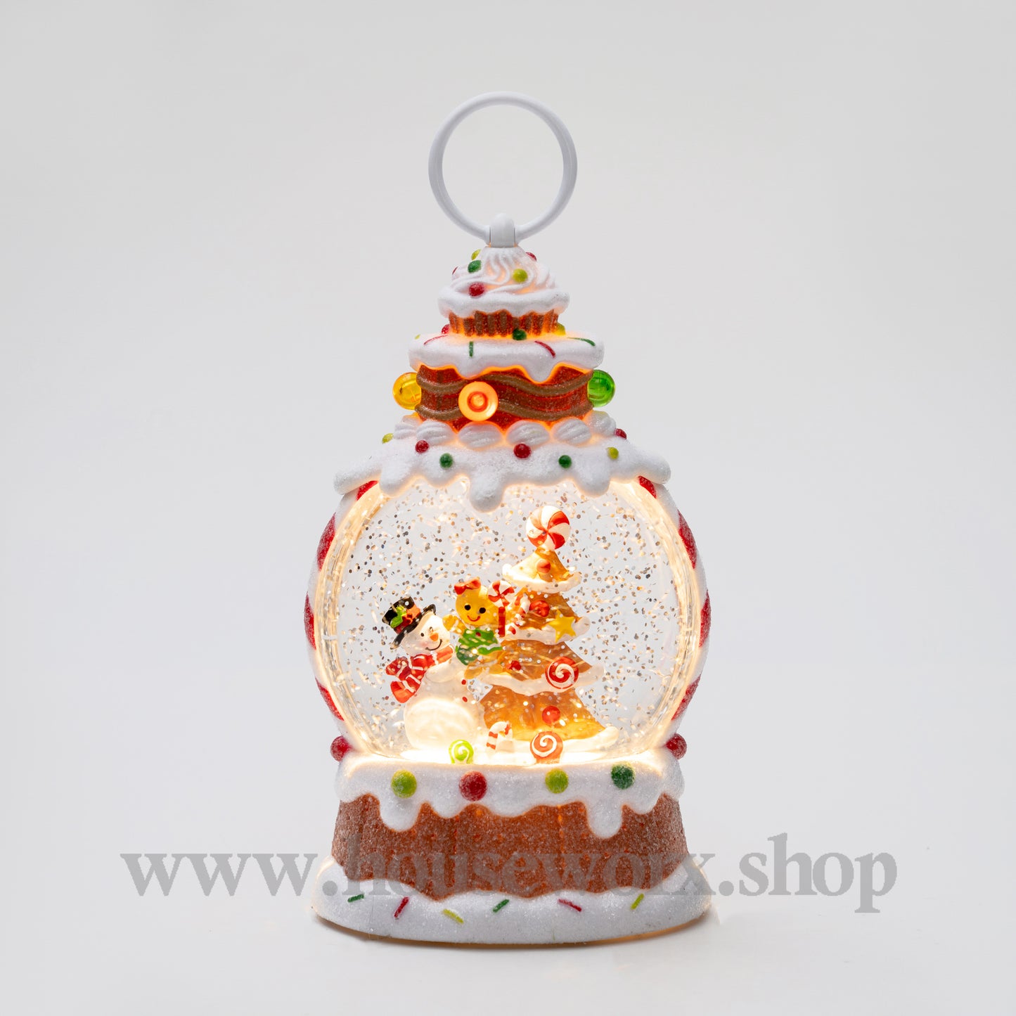 Decorative snow globe with a gingerbread house design on a white background