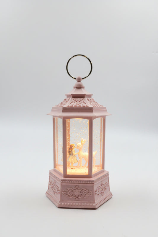 A pink decorative lantern with a hanging ring, featuring a warm glowing fairy light inside, set against a plain gray background.