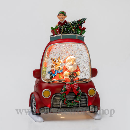 Decorative Christmas scene in a red car with Santa Claus and reindeer inside, on a white background.