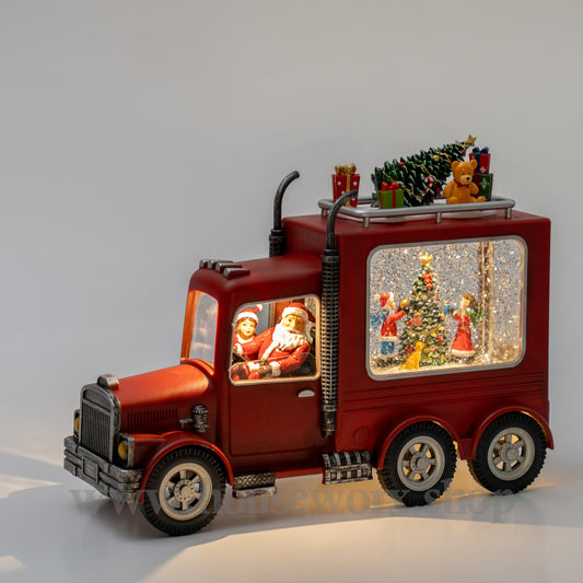 Decorative red truck with Christmas scene inside snow globe on a gray background