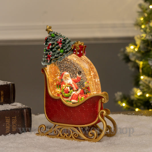 Decorative Christmas scene with Santa in a sleigh, tree, and presents on a snowy surface.