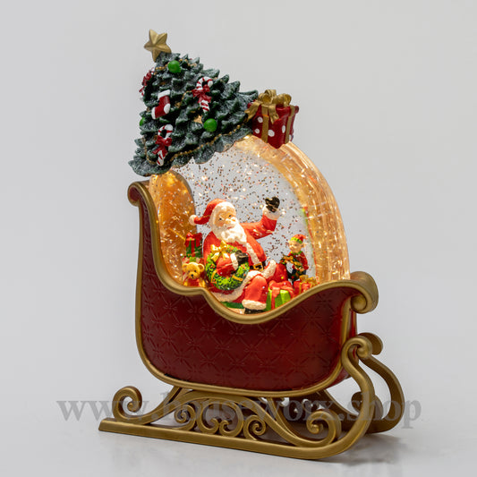 Decorative Christmas snow globe with Santa Claus in a sleigh, surrounded by trees and gifts.