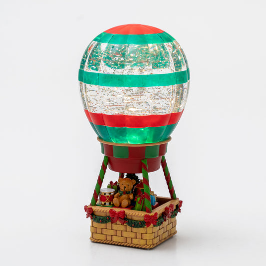 Decorative hot air balloon with a basket containing a teddy bear on a white background christmas snow globe