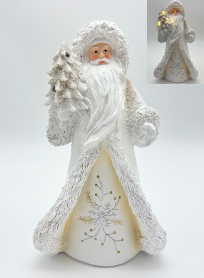 A white Santa Claus figurine holding a small decorated Christmas tree, shown on a light gray studio background with a small inset image in the top right showing the figure lit from within.