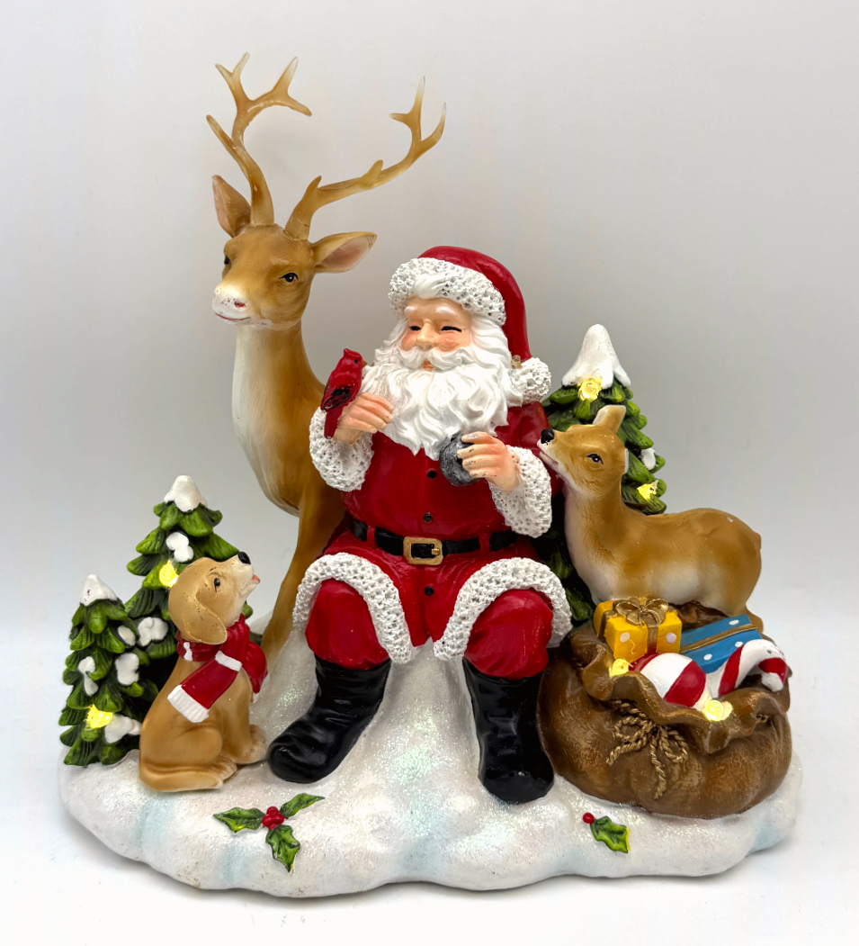 Christmas scene of Santa with reindeer, fawn, puppy and cardinal on a glittering snowy base. A glowing tabletop piece from our Frosty Hollows collection.