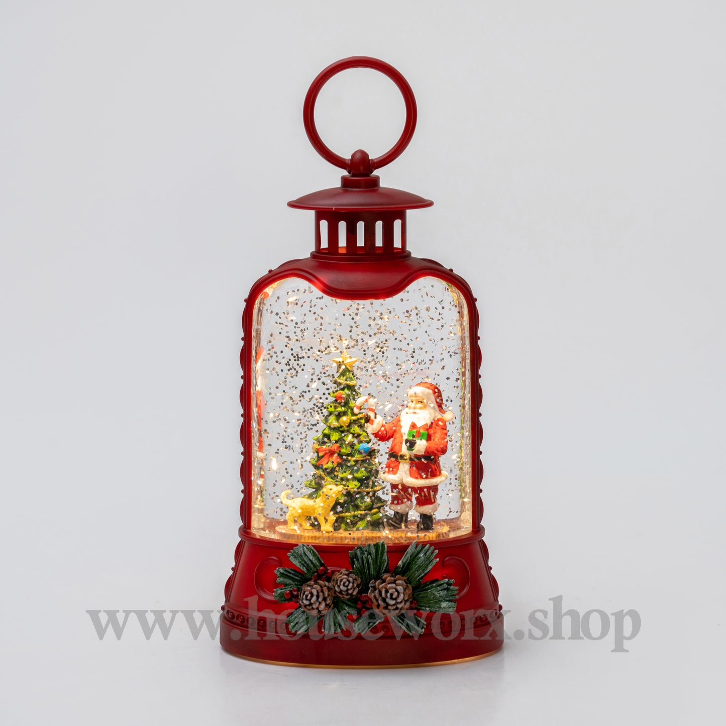 Red lantern-shaped snow globe with Santa Claus and a Christmas tree inside on a light gray background.