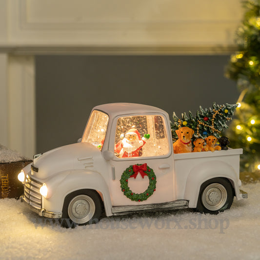 Decorative Christmas truck with Santa Claus and ornaments in a snowy setting. christmas snow globe