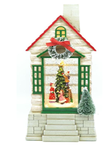 A holiday-themed lantern featuring a snow-covered cottage with a Christmas tree and decorations.