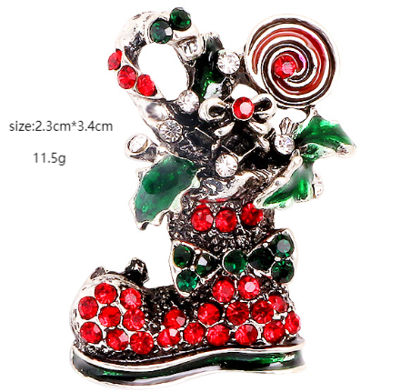 A brooch in the shape of a shoe with red and green embellishments and a silver twisted stem, size 2.3cm x 3.4cm.