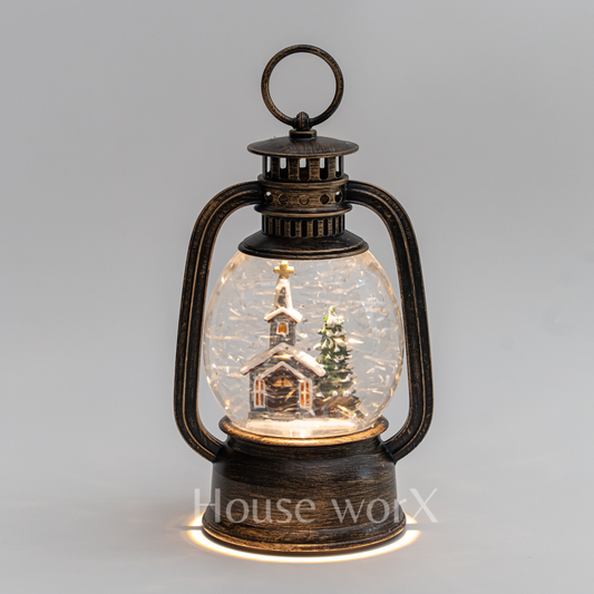 Decorative lantern with a miniature snowy scene inside on a gray background