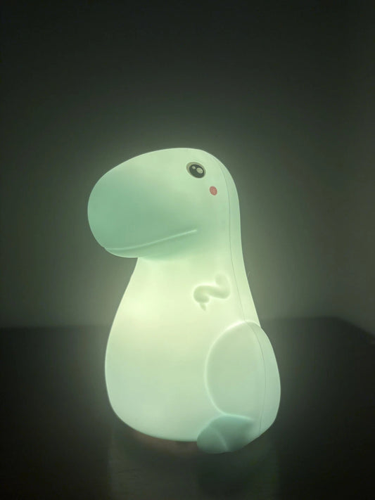Glowing dinosaur-shaped night light on a dark background