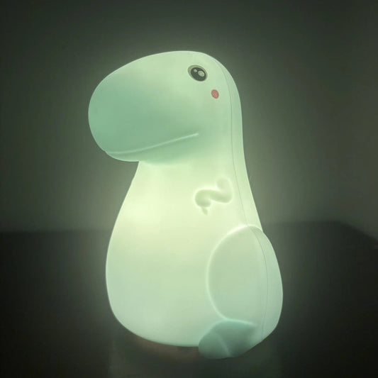 Glowing dinosaur-shaped night light on a dark background