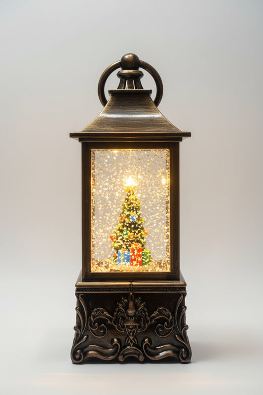 A decorative lantern-style Christmas light with a dark bronze metal frame, glowing warm white lights inside, and a small illuminated Christmas tree with colorful gift boxes on a white background.