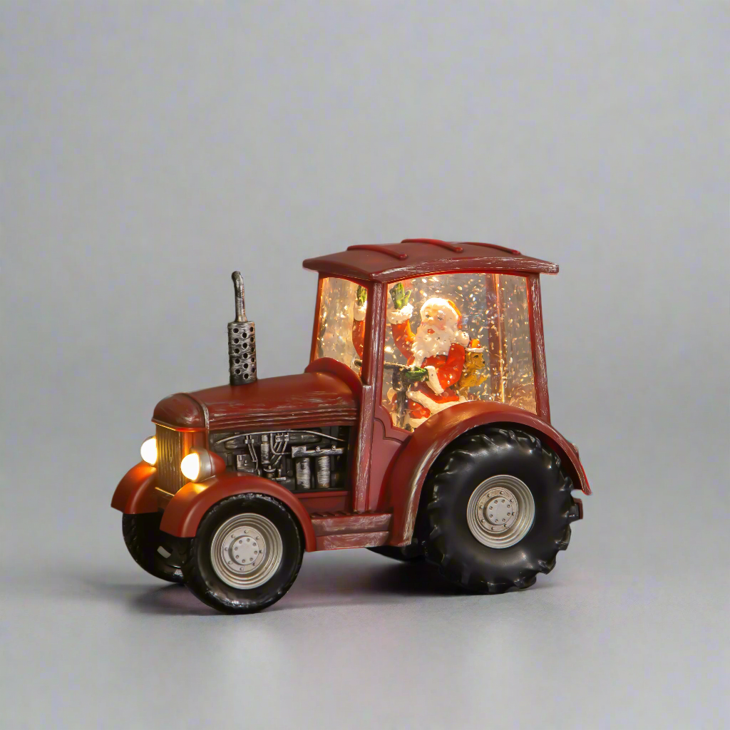 Decorative tractor with a Santa Claus figure inside on a gray background