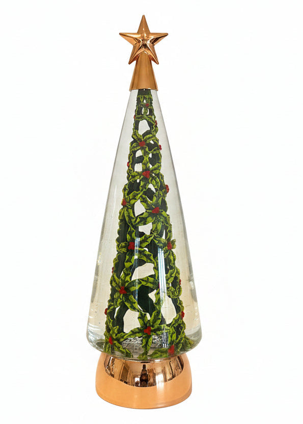 A decorative glass Christmas tree lamp with a gold star finial, green and red holly-patterned interior, and a metallic gold base, shown standing on a kitchen countertop with its box behind it.