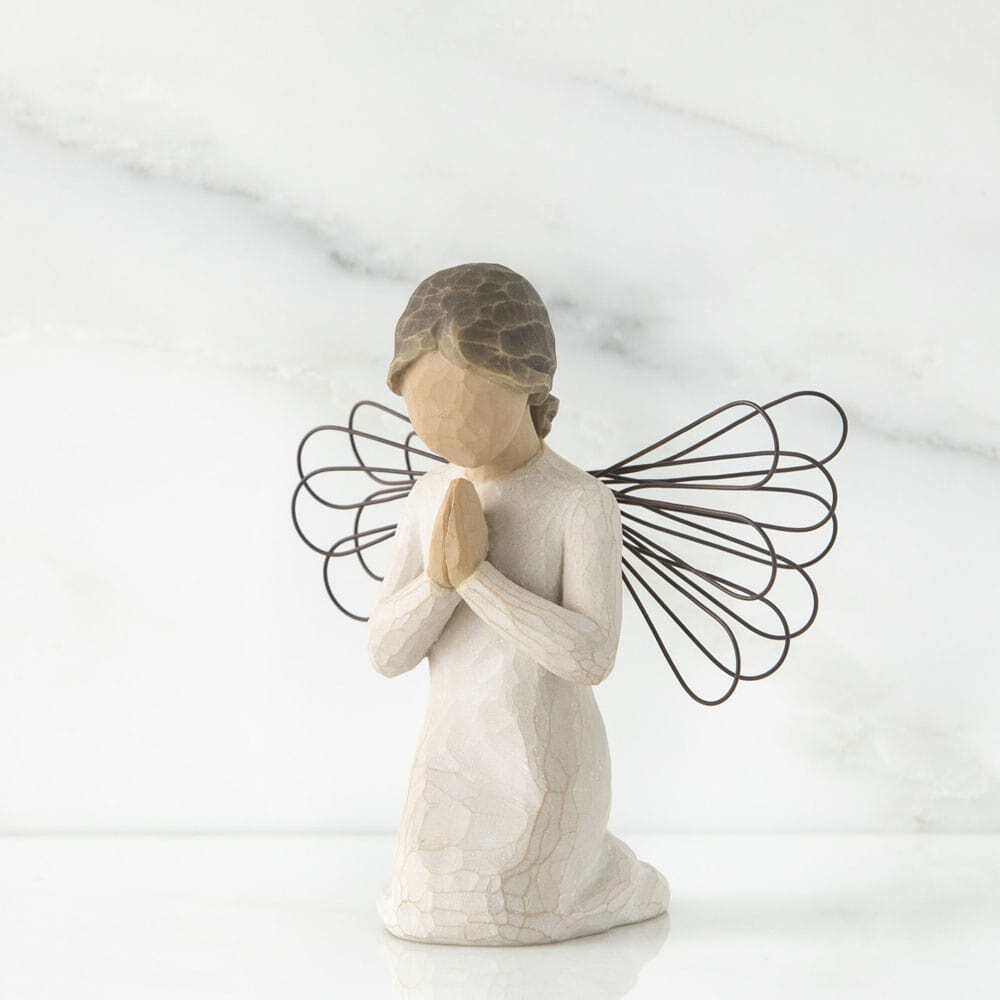 White angel figurine with wire wings on a white background
