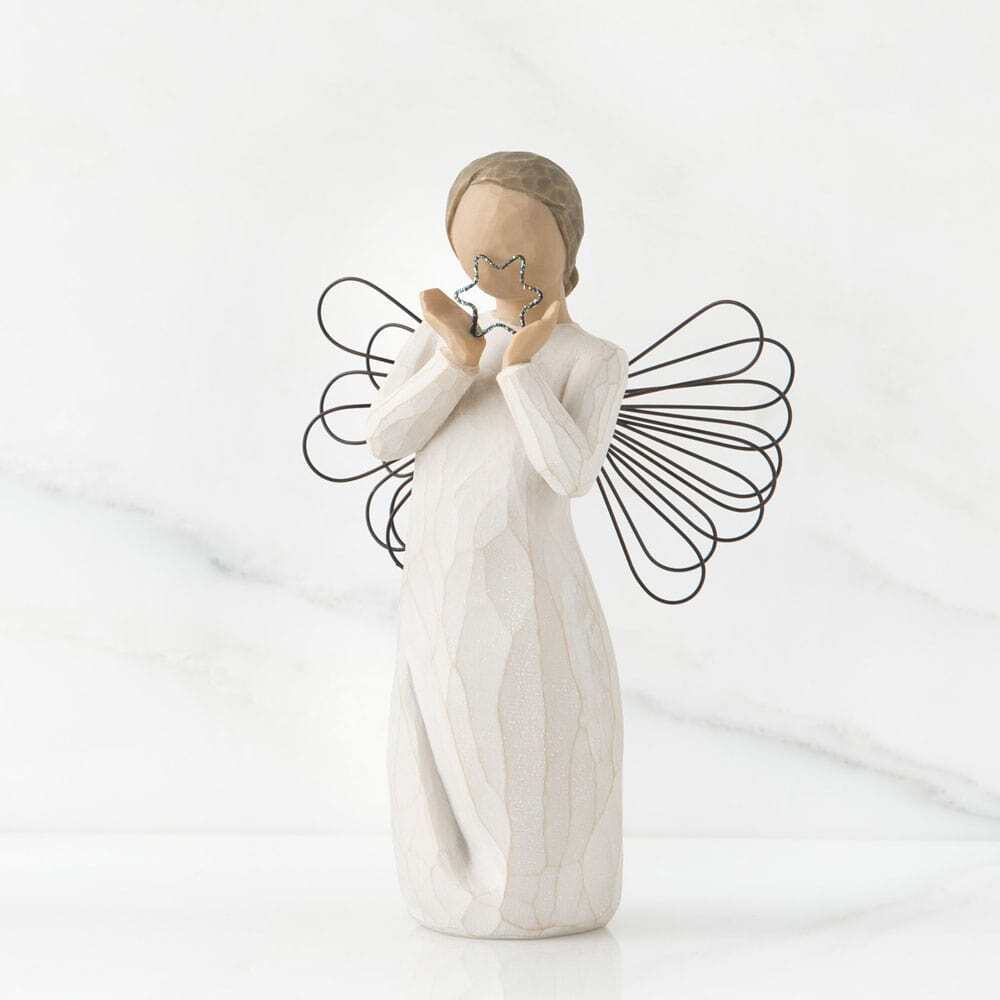 White angel figurine holding a star against a white background