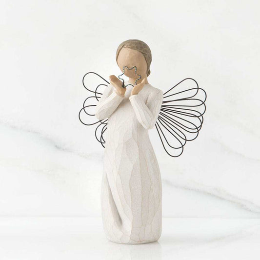 White angel figurine holding a star against a white background