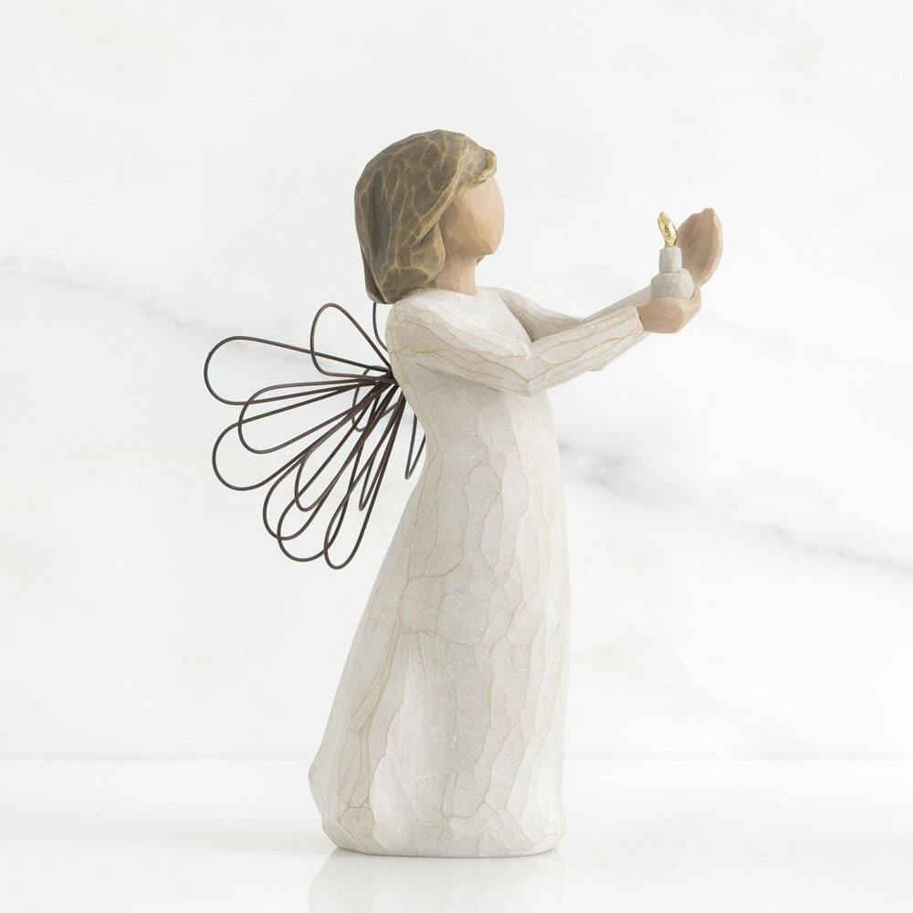 Angel figurine with outstretched wings and a light on a white background