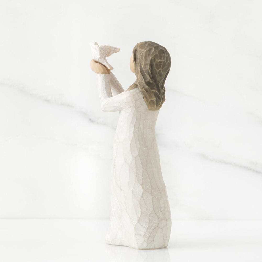 Ceramic figurine of a woman holding a bird on a white background