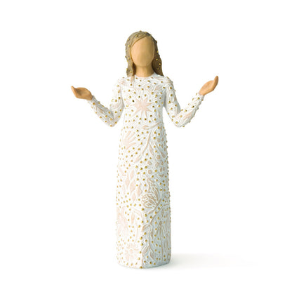 Figurine of a woman in a white dress with gold patterns on a white background