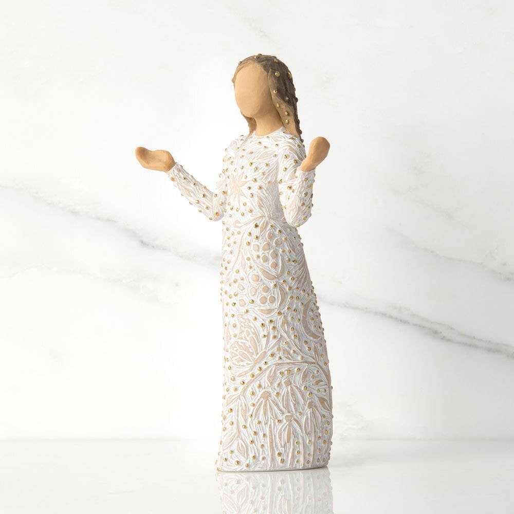 Statue of a woman in a white dress with lace details on a light gray background