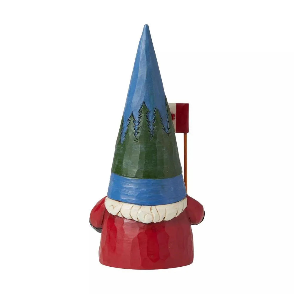 A hand-painted wooden gnome figurine with a tall blue and green hat, red body, white beard, and a small red flag on a stick.