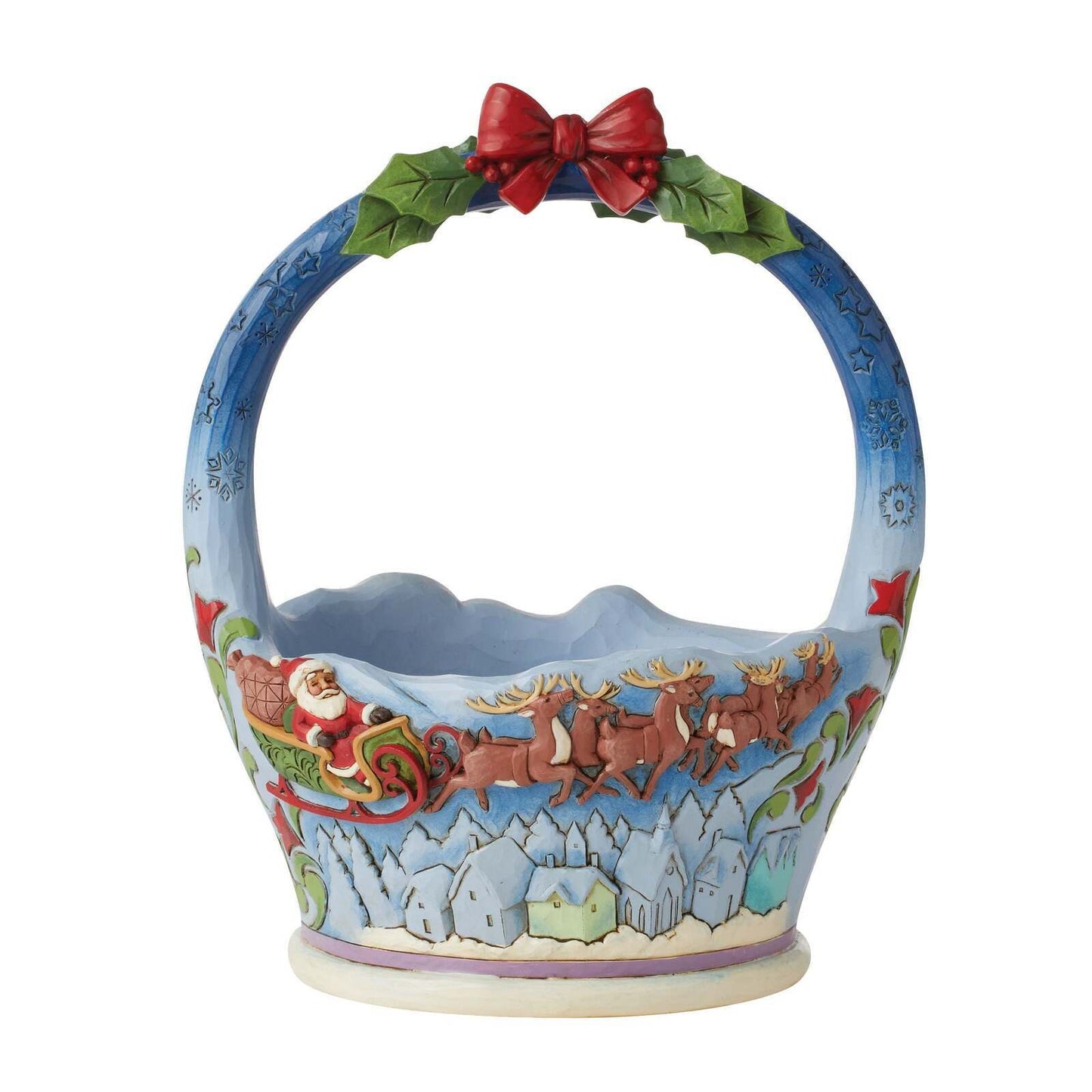 A ceramic Christmas basket featuring Santa Claus in sleigh with reindeer, a snowy village, and a holly wreath with a red bow on the handle, set against a plain white background.