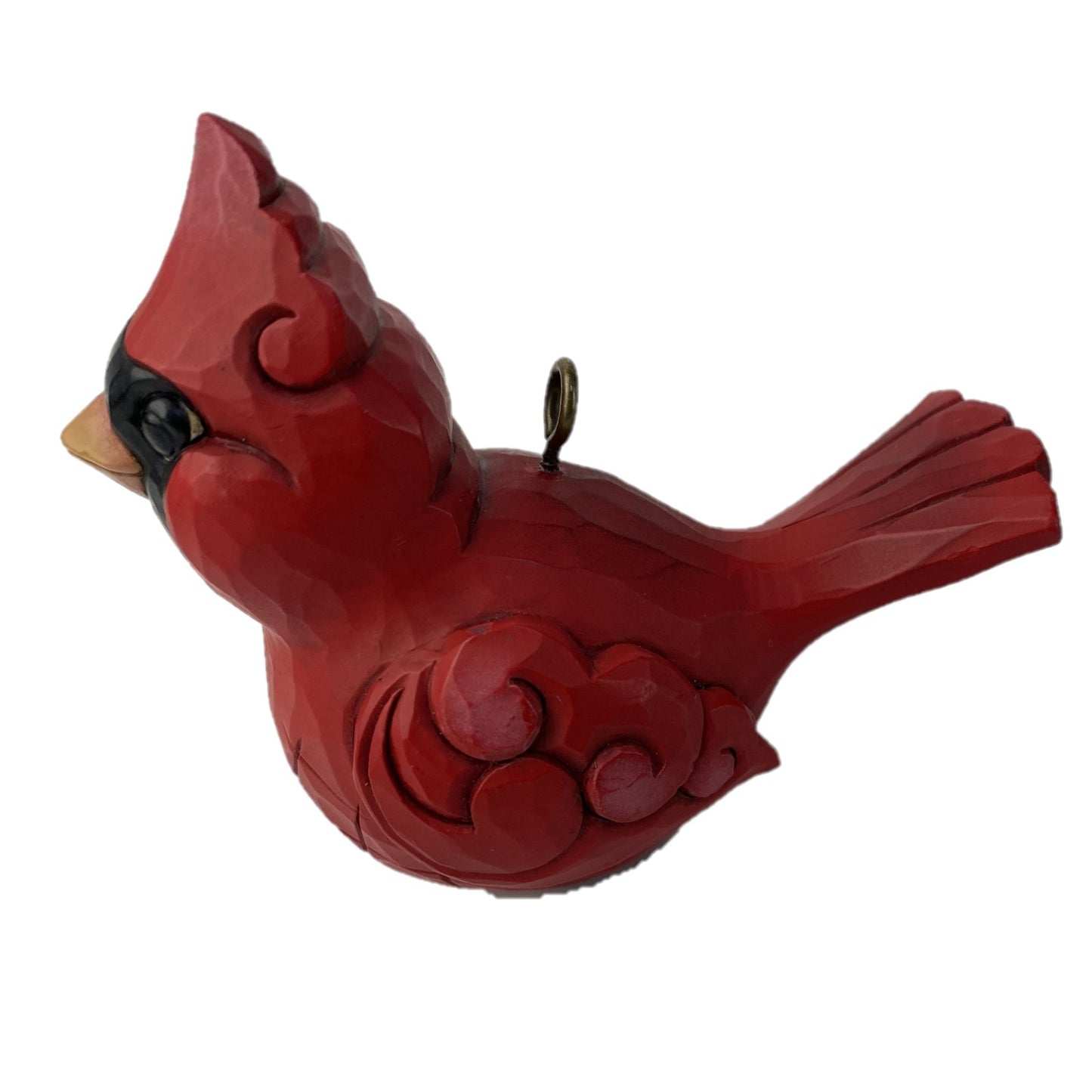 A red cardinal bird ornament with carved swirl details, a small black eye, a beige beak, and a metal hanging loop, shown on a plain white background.