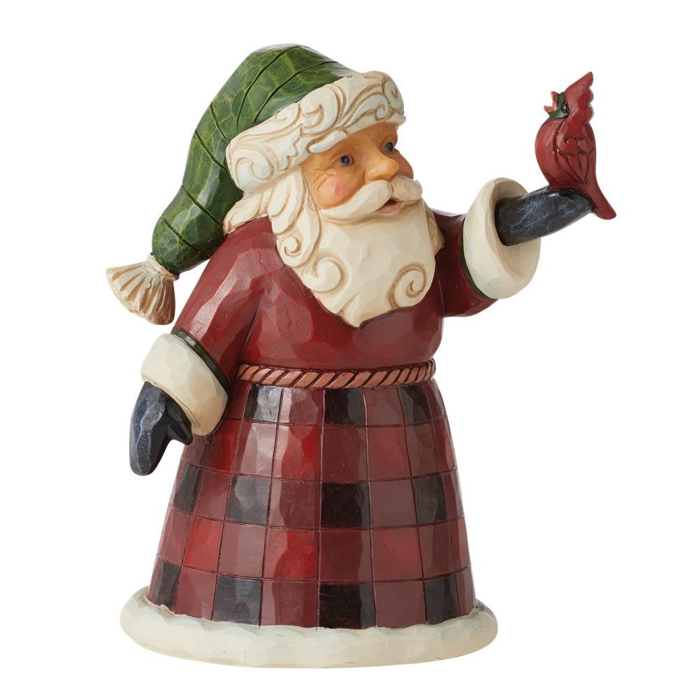 A Santa Claus figurine wearing a green and red checkered coat and hat, holding a small red cardinal on a branch, isolated on a white background.