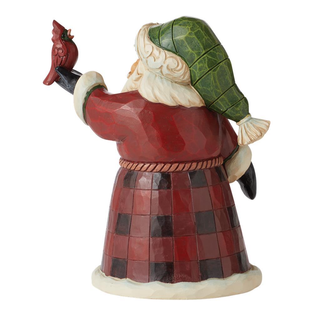 Decorative figurine of a Santa Claus holding a cardinal bird on a white background