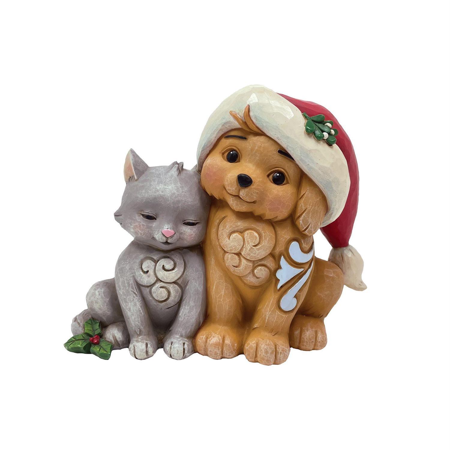 Figurine of a dog and cat sitting together, with the dog wearing a Santa hat on a white background.
