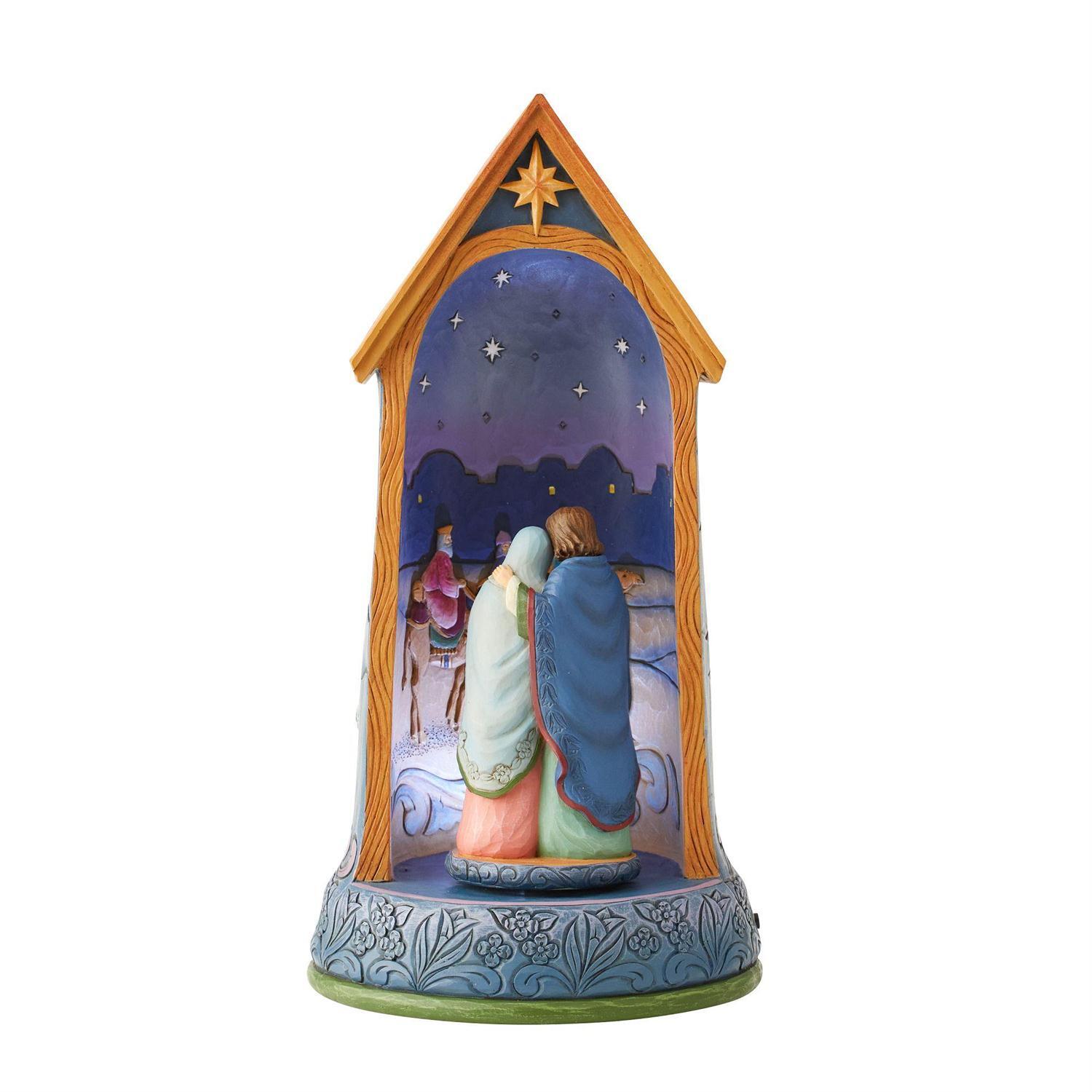 A decorative nativity scene figurine shaped like a house, featuring Mary, Joseph, and the Three Wise Men under a starry night sky. The figurine has a blue base with floral patterns and is set against a plain white background.