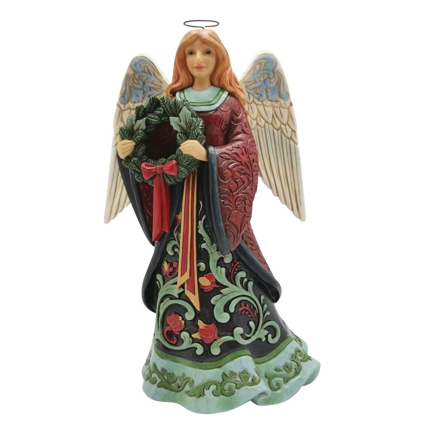 An angel Christmas ornament figurine with red hair, holding a green wreath with a red bow. The angel has large beige wings with blue accents and wears a dark red and black robe with green and red floral patterns.