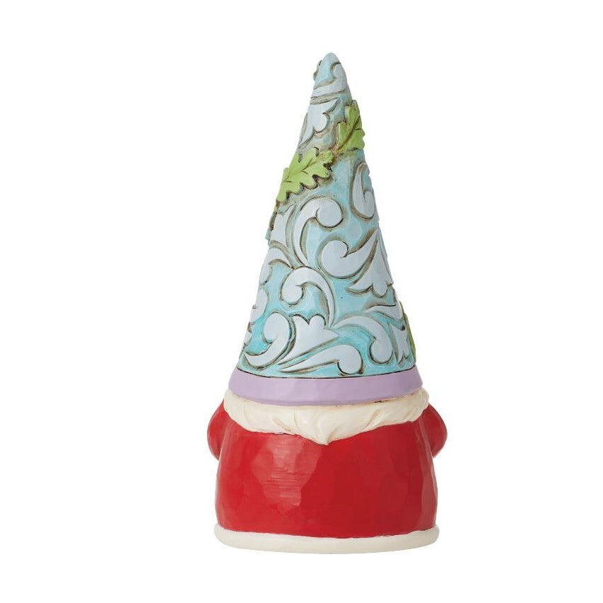 A decorative gnome figurine with a red hat, cream beard, and a pointed blue and white patterned hat decorated with green leaves, set against a plain white background.