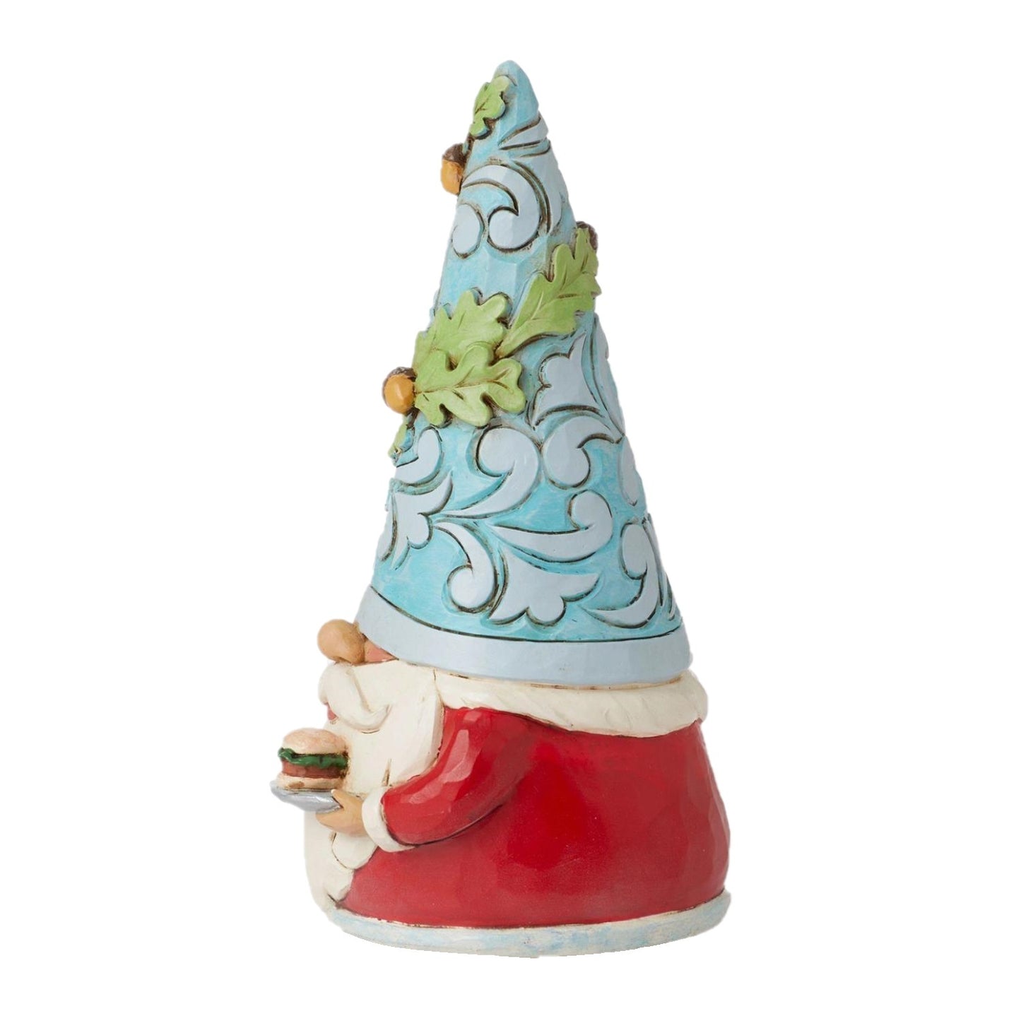 A decorative gnome figurine shown from the back, wearing a tall pointed light blue hat with white scrollwork and green leaf accents, a red coat, and a white beard, holding a small green item in one hand.