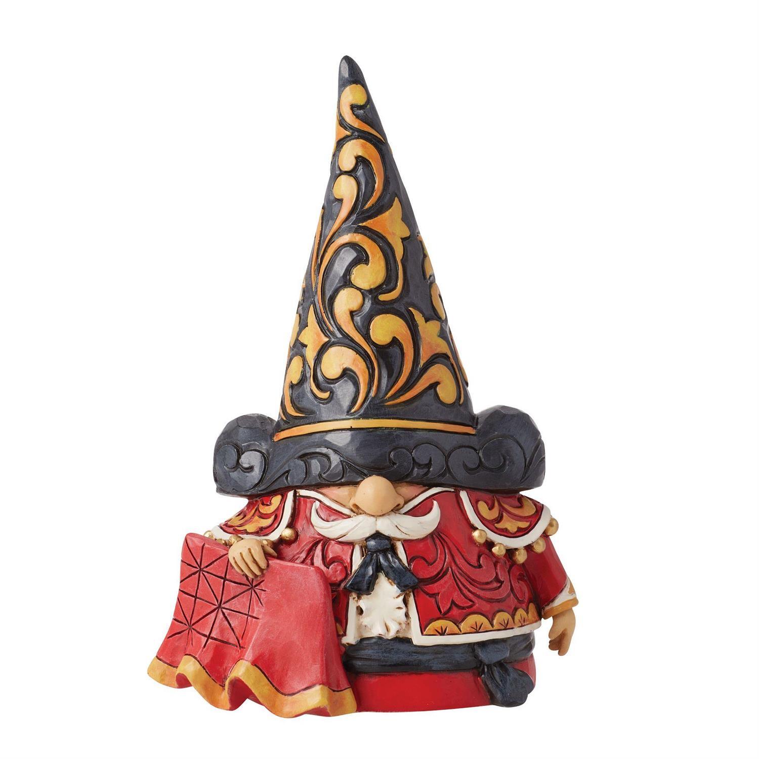 A Jim Shore collectible figurine of a gnome wearing a tall black hat with gold scrollwork, a red robe with gold trim, and a white mustache, shown on a plain white background.
