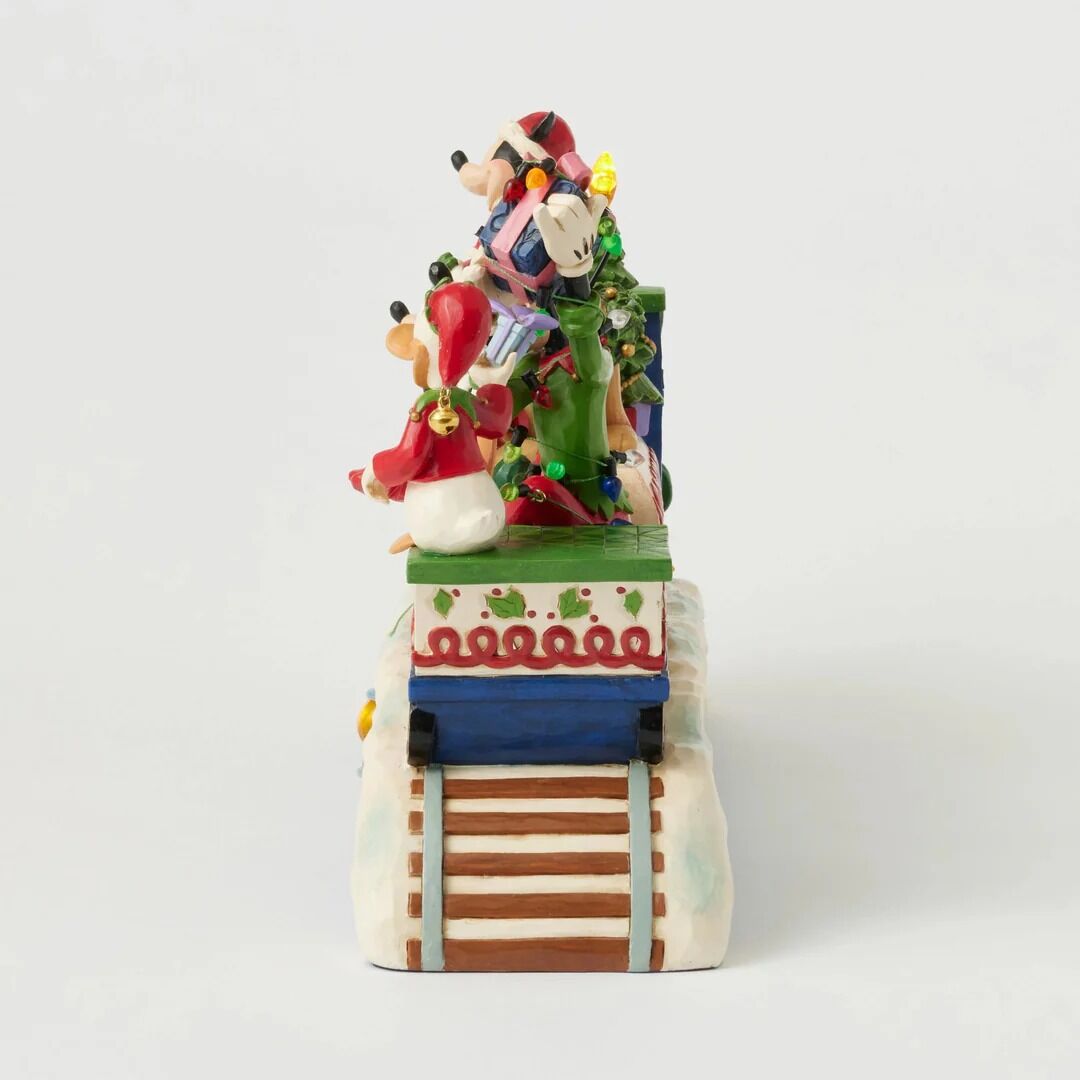 A festive ceramic figurine of Mickey Mouse and Minnie Mouse riding a decorated train, set against a plain light gray background.