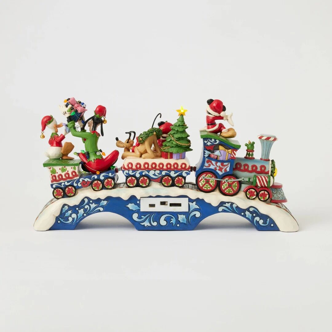 A colorful Christmas-themed decorative train figurine with Santa Claus, a sleigh, reindeer, a Christmas tree, and passengers on a white studio background.