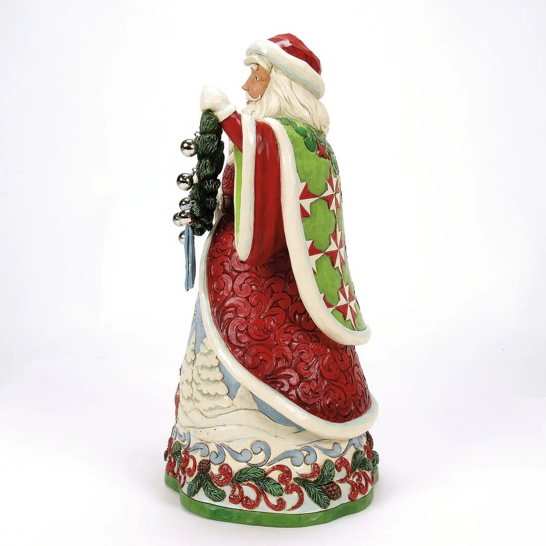 Decorative figurine of a Santa Claus holding a bell on a white background
