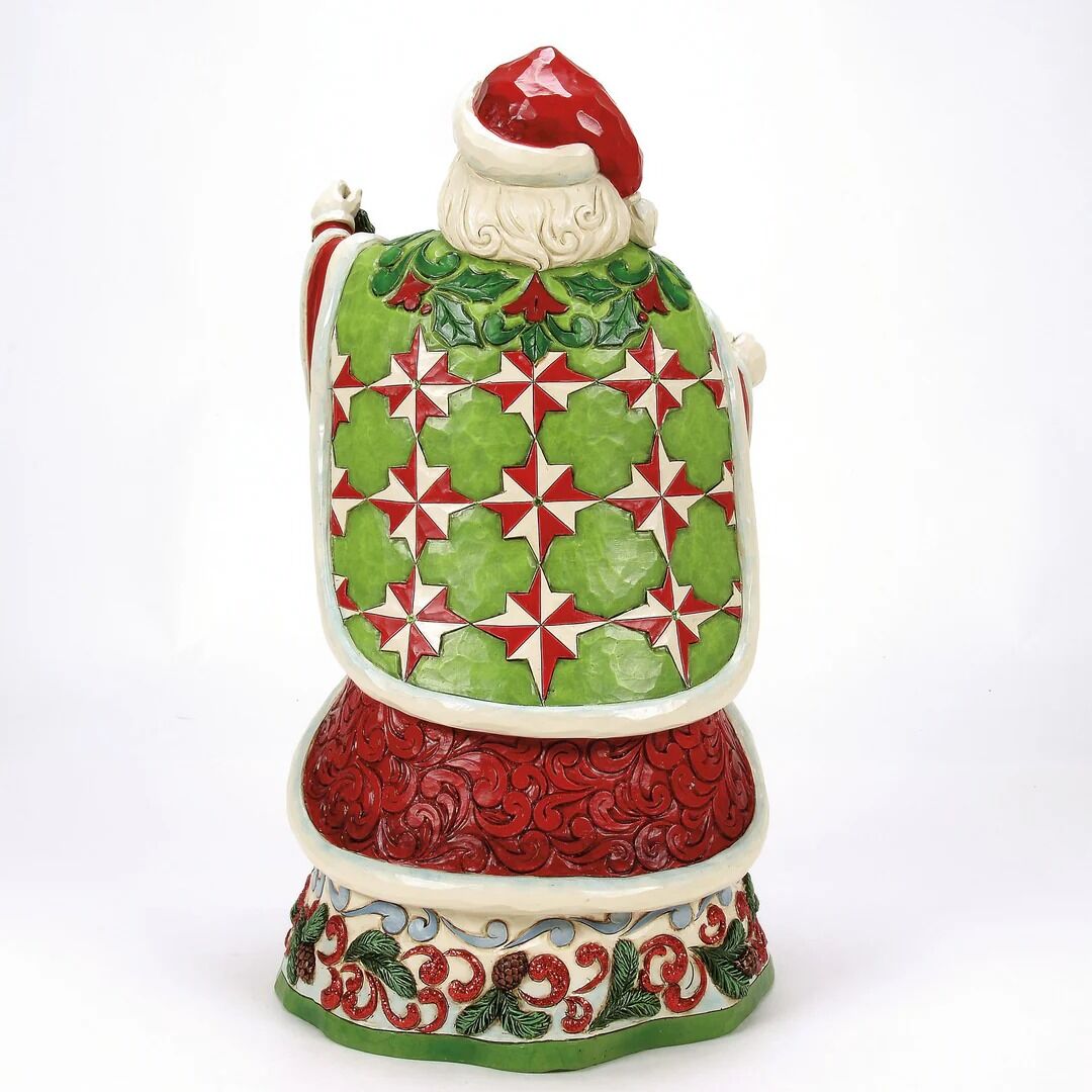 Decorative Santa Claus figurine with a green and red patterned apron on a white background