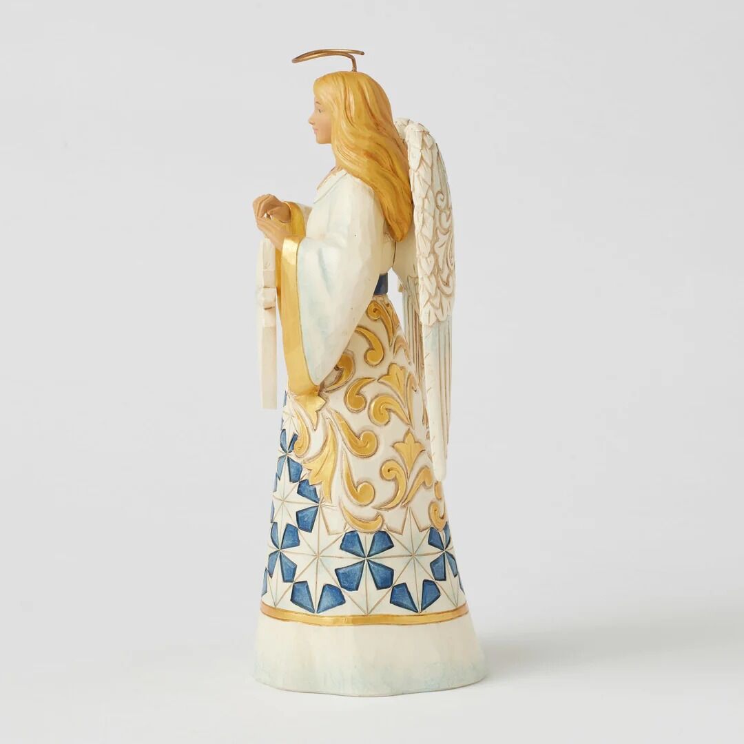 An angel figurine shown from the side, featuring long blonde hair, a gold halo, a white robe with gold scrollwork, and a blue and white star-patterned skirt, set against a plain light gray background.