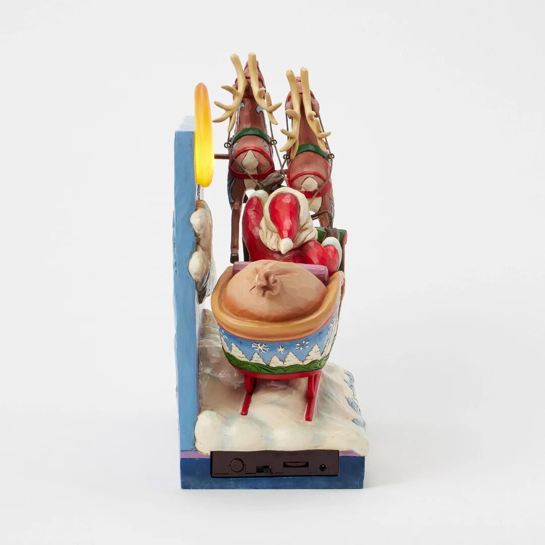 Decorative figurine of Santa Claus in a sleigh with reindeer on a white background