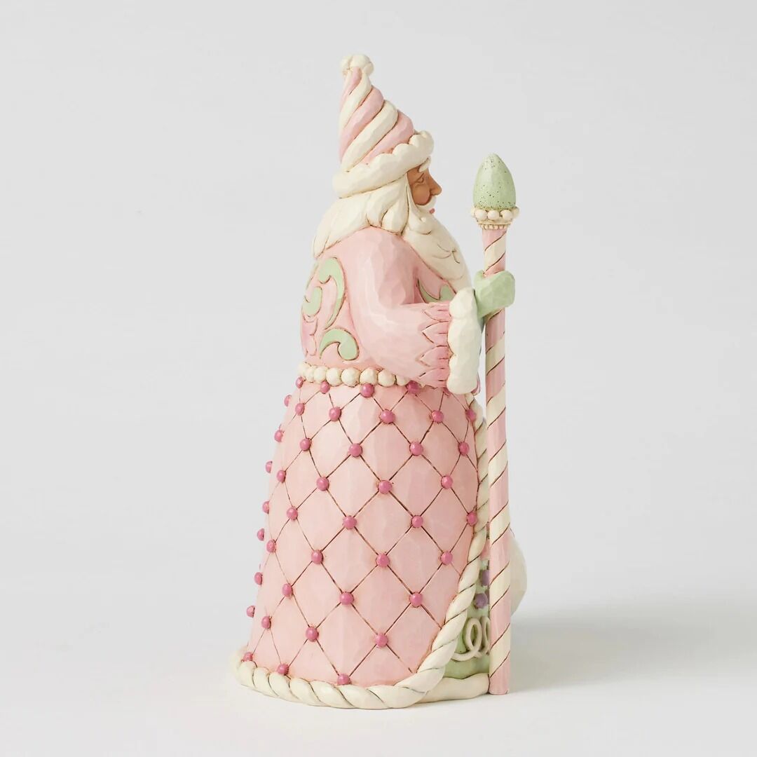 A pink and white Santa Claus figurine shown from the side, holding a matching staff, photographed against a clean white background.