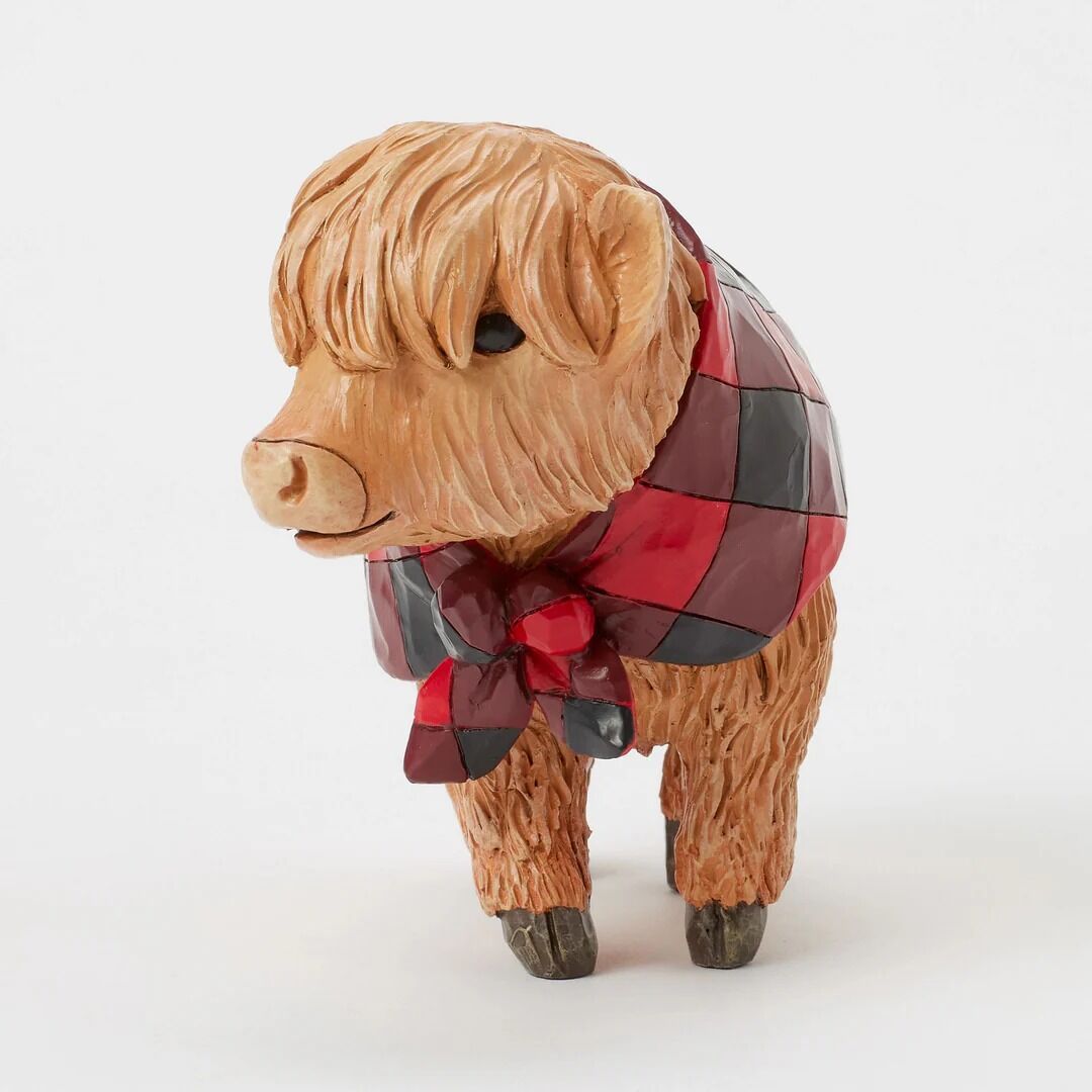 A Highland cow figurine with shaggy light brown hair and a red, black, and brown plaid blanket, standing against a plain white background.