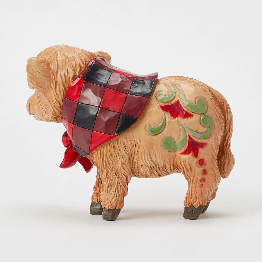 Decorative figurine of a cow with a checkered red and black pattern on a white background